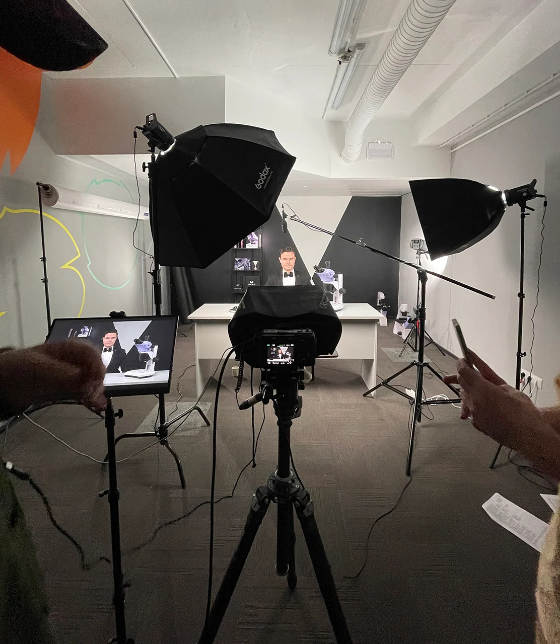 Wide shot of the MAGUS video review set with presenter, cameras, and lighting