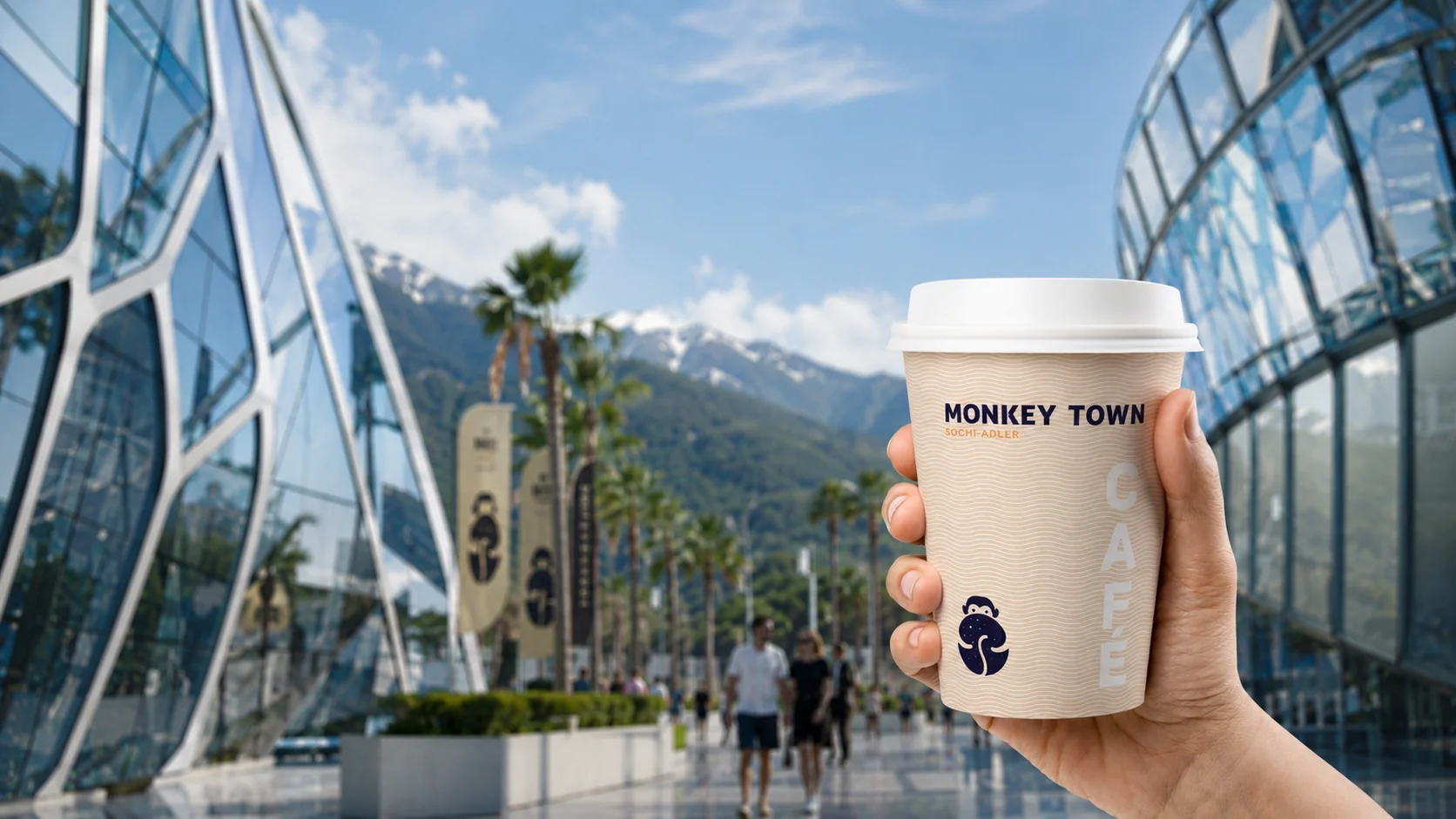 MonkeyTown branded cup against the park architecture