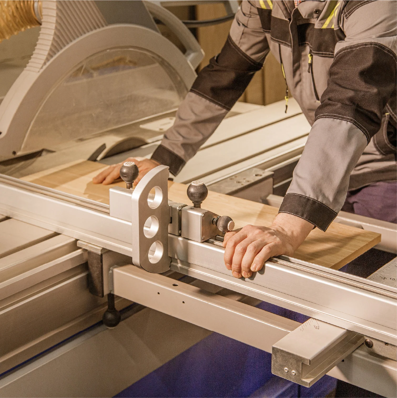 Specialist cutting a wood panel on a sliding table saw